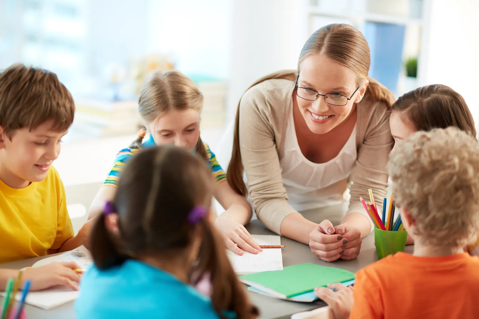 Educadora atendiendo a un grupo de niños en el aula